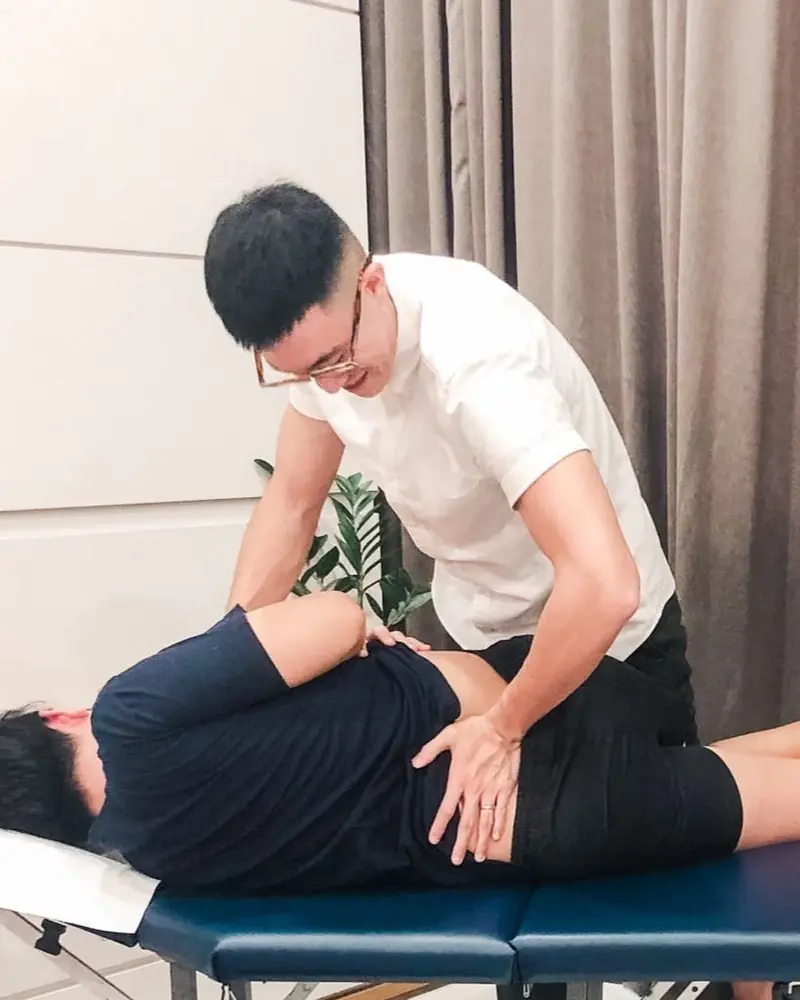 Dr. Ben carrying out a clinical assessment on a treatment table